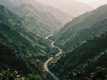 Misty mountain pass of Ma Phuc at golden hour, winding road, lush green valleys, 35mm film aesthetic