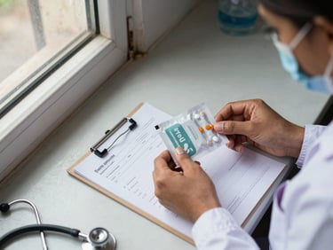 Overhead view of a nurse's hands arranging medicine packets on a clinic counter in Patna, natural window light from the left, a prescription pad and stethoscope visible at the edge