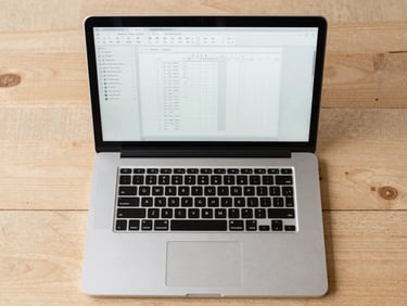 A clean, top-down flat-lay of a designer's desk with a laptop displaying a blueprint-style file organization interface. Soft morning daylight, sharp grid alignment.