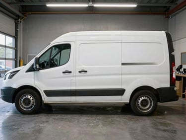 Clean used white utility transporter van parked inside a modern garage, side angle