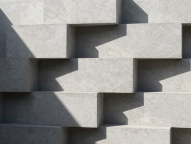 Minimalist composition of raw concrete blocks stacked under sharp sunlight, deep architectural shadows, clean lines, premium material texture