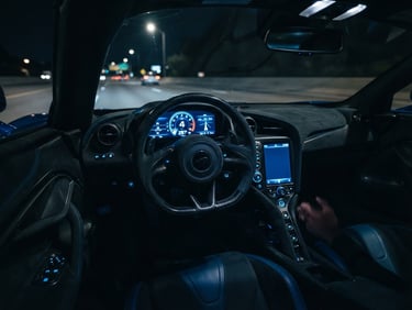 Low-angle cinematic shot of a modern supercar cockpit at night, glowing digital dashboard with electric blue accents, carbon fiber details, shallow depth of field.