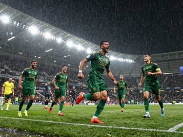 Low-angle dynamic shot of players celebrating a goal in the rain, splashing water, stadium lights