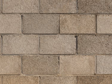 Close-up of clean, freshly struck mortar joints in a massive CMU block wall, hard morning light, gritty industrial texture