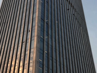 Abstract architectural detail of a modern steel and glass skyscraper facade in Gurgaon, sharp angles, sunset light reflection, deep navy tones