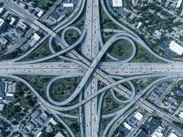 Top-down orthographic view of a complex highway junction, sharp vector GIS contours overlaid, crisp technical daylight, cool slate and electric blue tones