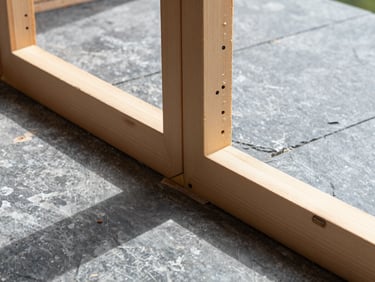 Close-up of clean framing timber joints in a modern home renovation, natural high-contrast daylight