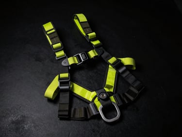 High-contrast industrial photography of tactical safety harness and rugged rescue gear on a matte black surface, sharp neon highlights, dramatic low-key lighting