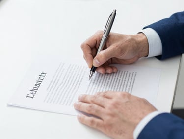 Close-up of professional hands signing an official document with a fountain pen, bright neutral lighting