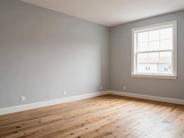 Full-room wide shot of a freshly renovated empty living room — smooth replastered walls painted light grey, new skirting boards, clean stripped wood floor, natural daylight through large window, no furniture yet
