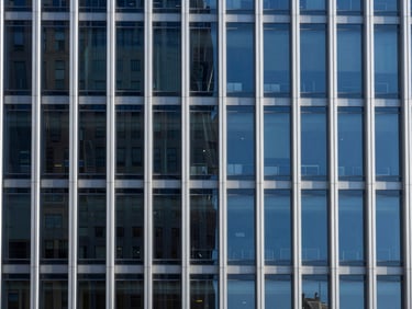 Abstract architectural geometry of a modern building facade in New York, clean lines, cool light, representing structure and security, deep blues.