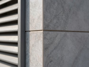 Architectural close-up of a UV marble sheet wall panel seam meeting a WPC louver strip, daylight from the left revealing surface grain and panel joint precision