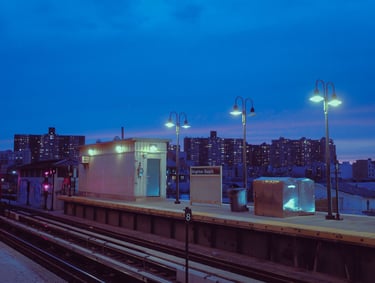 A blue hour shot of a train station, lanterns softly lighting the scene.