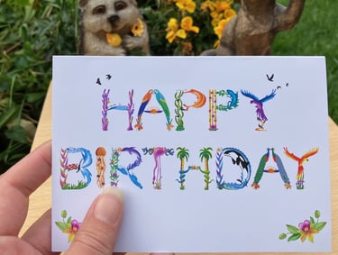 A greeting card with the words Happy Birthday printed in tropical exotic word art