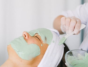 therapist apply clay mask with brash on face 