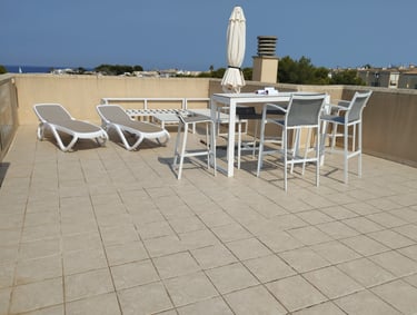 a patio with a table and chairs and umbrellas
