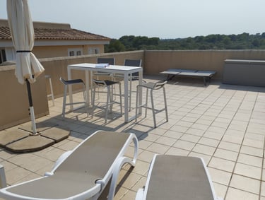 a patio with chairs and umbrellas on a sunny day