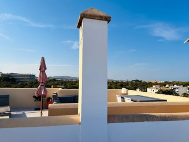 a bird flying over a rooftop patio with umbrellas