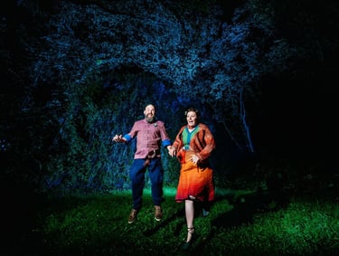 a couple of people standing in the grass