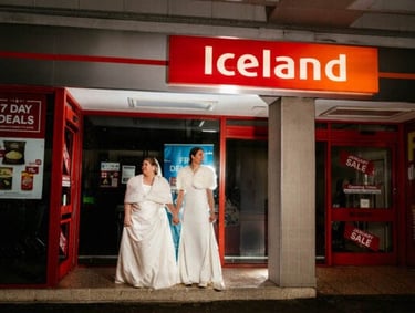 a couple of bridesmaid standing in front of an Iceland Food store