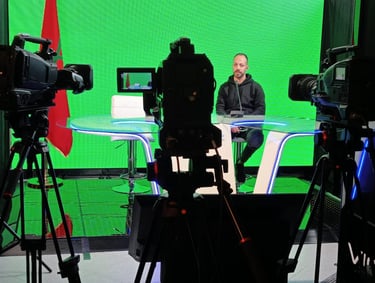 a man sitting at a table with a laptop and camera