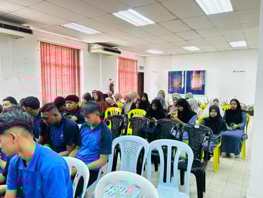 A group of students sitting in a training seminar room during a university orientation or lecture session.
