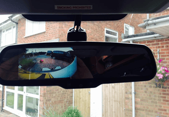Rear-view mirror with built-in reversing camera display showing parking guidance lines.
