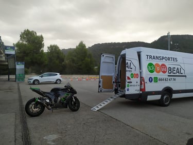 Furgoneta de Transportes Beal con rampa desplegada, lista para cargar una motocicleta.