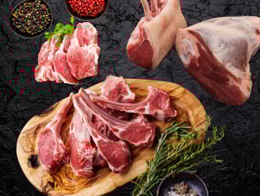 Agneau halal cru : côtelettes, morceaux et gigot avec herbes fraîches sur planche.