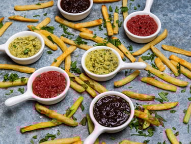 Sustainable plant-based sauces displayed in small white dishes with potato chips surrounding