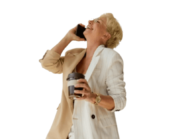 a woman in a white coat and a cell phone- smiling as she talks to an ai voice assistant.