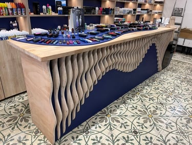 Modern vape shop interior featuring a wooden wave display counter with various e-cigarettes and bottled e-liquids.