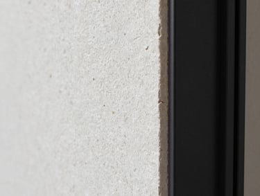 Macro photography of refined construction finishes, focusing on the texture of a polished white stone wall meeting a matte black metal frame, modern and sophisticated aesthetic, soft studio lighting.