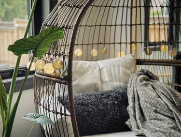 Cozy hanging lounge chair with soft cushions, warm lighting and natural textures for relaxed outdoor