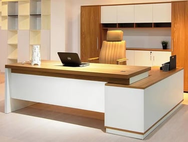 Modern executive L-shaped wooden desk with a laptop and leather chair in a contemporary home office.