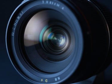 Extreme close-up of a premium cinema lens, reflection of studio lights, sharp focus, dark blue tones