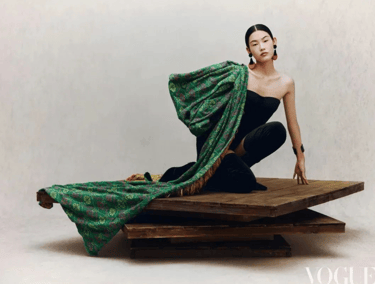 Editorial fashion shoot featuring luxurious green draped textile.