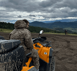 a man in a camouflager outfit is riding a atv