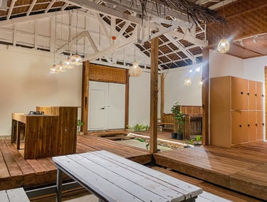 Eco-friendly modern tropical interior with wood decking, woven pendant lights, and exposed rafters.