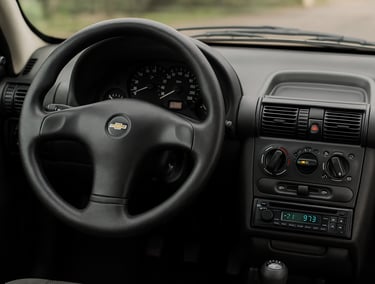 Interior de um Chevrolet Corsa com painel simples e volante original bem conservado. Ask Cha