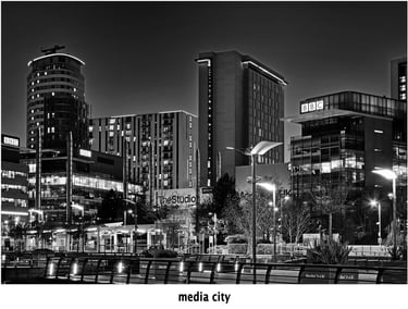 a cityscape of media city at salford quays after dark