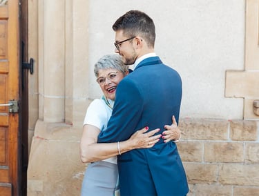 Marié en costume qui étreint sa maman à la sortie de la mairie