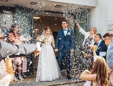 Mariés qui sortent de la cérémonie religieuse sous une pluie de confettis.