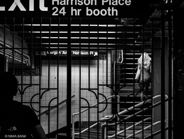 a woman walking through a subway station with bars in the foreground