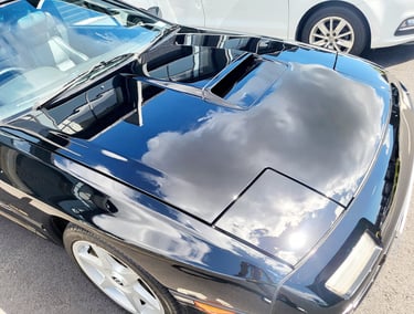 Close-up of a glossy black sports car with paint correction and ceramic coating at The Coating Lab A