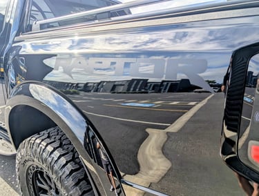 Side view of a black Ford F-150 Raptor truck with graphene coating applied by The Coating Lab