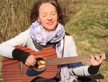 eine junge Frau - Sina Weidlich - spielt Gitarre in der Natur
