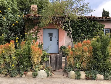 Pink adobe Santa Barbara home with succulent and flower garden.
