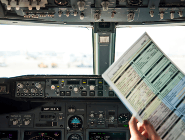 Pilot with flight checklist in cockpit – step-by-step Flight Plan coaching.