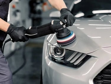 a man in a uniform polishing a car
